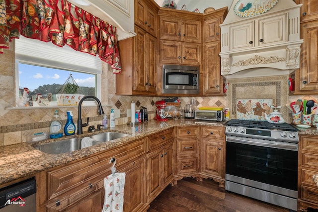 kitchen with dark hardwood / wood-style flooring, sink, light stone counters, custom range hood, and appliances with stainless steel finishes