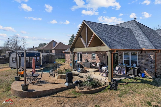 rear view of house with a storage unit, a patio, and a yard