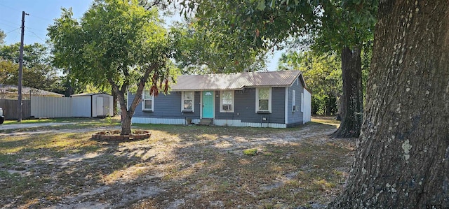 single story home featuring a shed