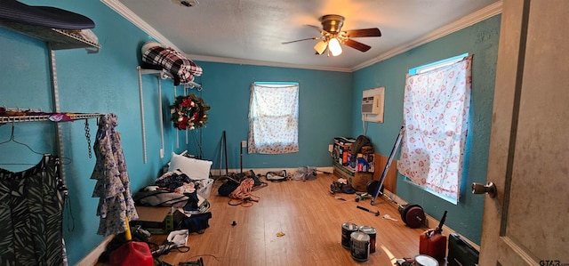 bedroom with ornamental molding, an AC wall unit, hardwood / wood-style flooring, and ceiling fan