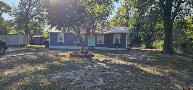 view of front of property featuring a storage shed