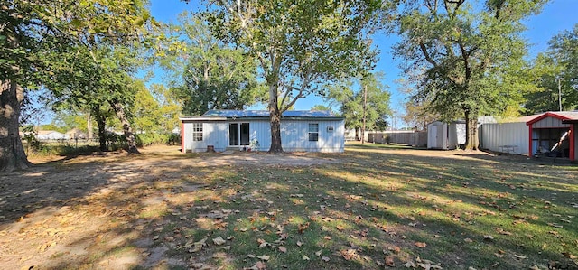 back of house with a lawn and a storage shed