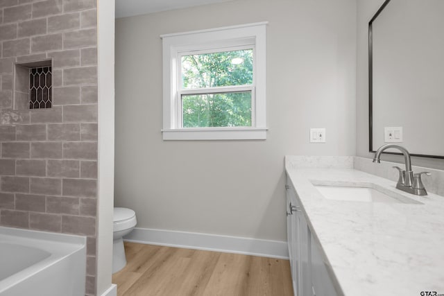 601 N 4th St, Crockett, TX 75835 - full bath with wood finished floors, vanity, a tub to relax in, toilet, and baseboards