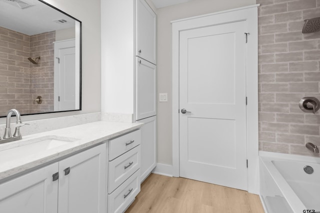601 N 4th St, Crockett, TX 75835 - bathroom with wood finished floors, vanity, and tub / shower combination