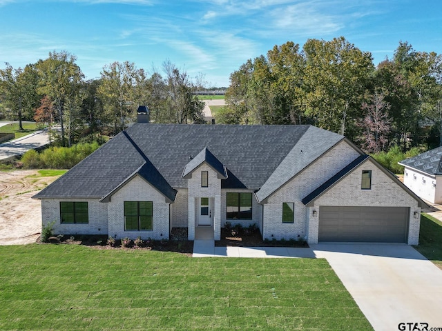 french country style house featuring a front lawn and a garage