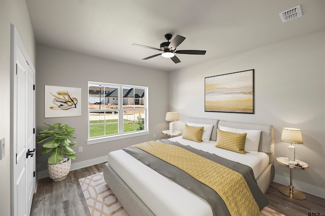 bedroom featuring a closet, dark hardwood / wood-style floors, and ceiling fan