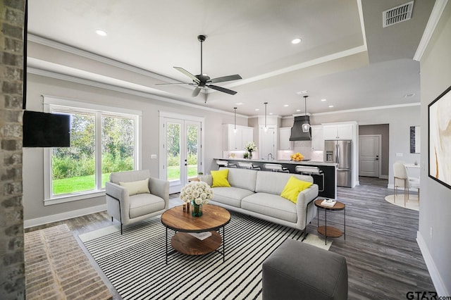 living room featuring crown molding, french doors, ceiling fan, and dark wood-type flooring