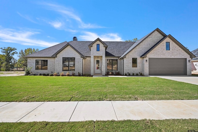 french country home featuring a front yard and a garage