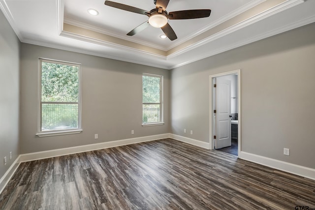 empty room featuring dark wood-type flooring, a wealth of natural light, and crown molding