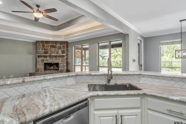 kitchen featuring white cabinets, decorative backsplash, hanging light fixtures, sink, and stainless steel dishwasher