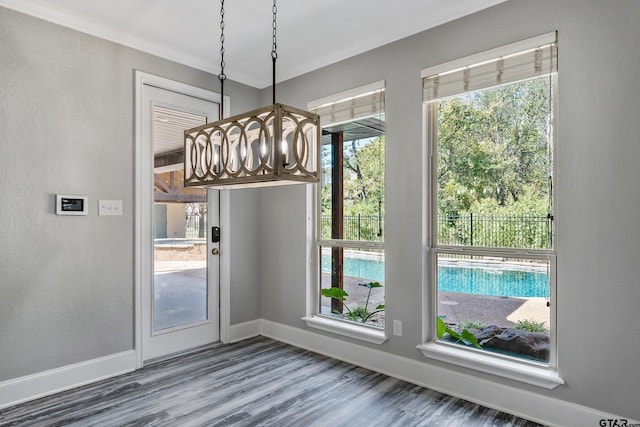 unfurnished dining area with wood-type flooring and crown molding