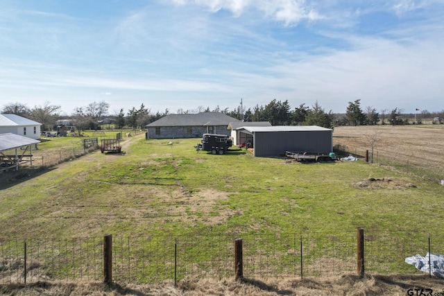 view of yard with a rural view and an outbuilding