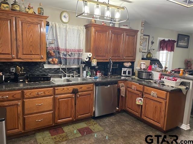 kitchen featuring tasteful backsplash, stainless steel dishwasher, and sink