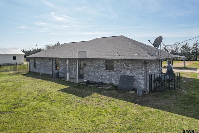 back of house featuring a lawn and central air condition unit