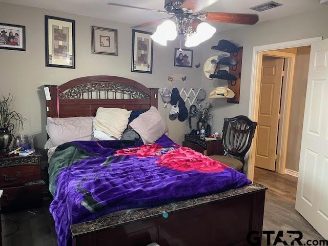 bedroom with ceiling fan and wood-type flooring