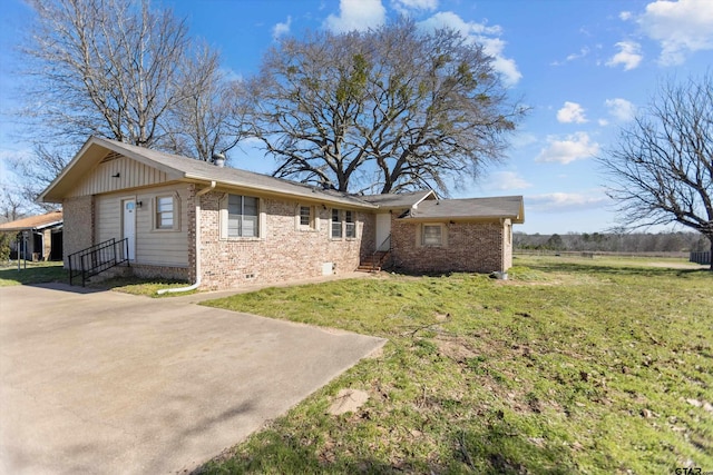 view of front facade with entry steps, a front lawn, concrete driveway, and brick siding