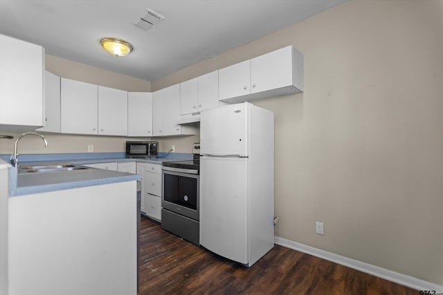 kitchen featuring stainless steel electric stove, visible vents, freestanding refrigerator, a sink, and under cabinet range hood