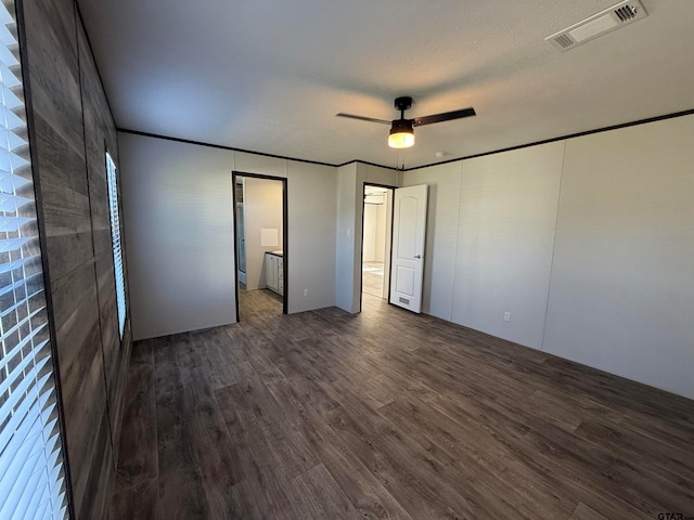 unfurnished bedroom with a textured ceiling, dark hardwood / wood-style floors, and ceiling fan