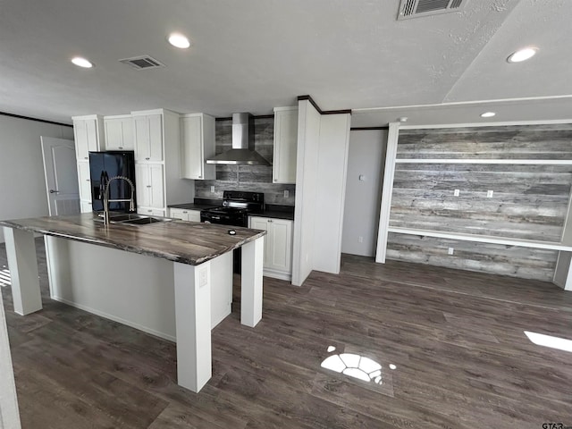 kitchen featuring a center island with sink, wall chimney exhaust hood, dark hardwood / wood-style floors, and white cabinets