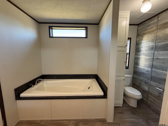 bathroom featuring ornamental molding, a bath, a textured ceiling, and hardwood / wood-style flooring