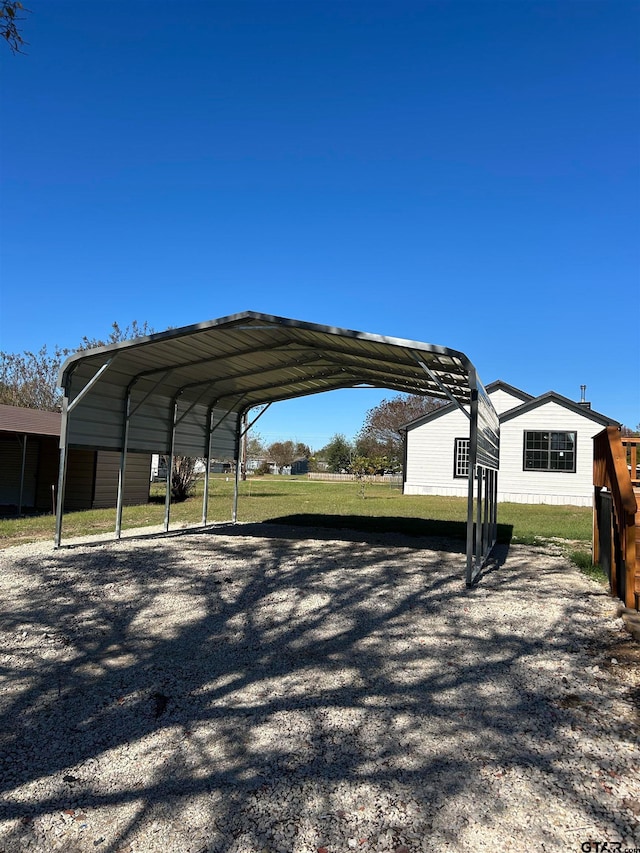 view of parking with a carport and a yard