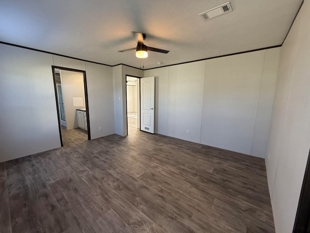 unfurnished bedroom with a textured ceiling, dark hardwood / wood-style floors, ceiling fan, and ornamental molding