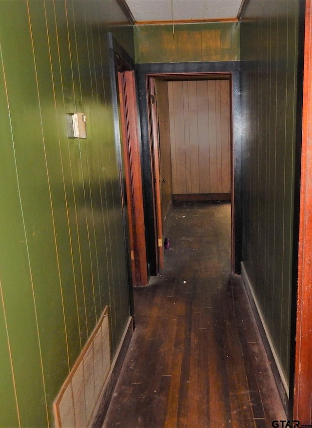 hall featuring wooden walls and dark hardwood / wood-style floors