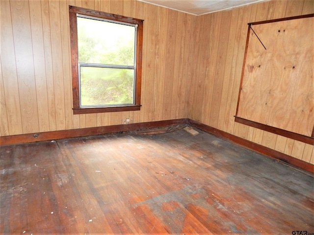 empty room with wooden walls and dark hardwood / wood-style floors