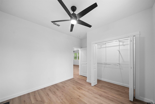 unfurnished bedroom featuring a closet, visible vents, light wood-style flooring, baseboards, and a ceiling fan