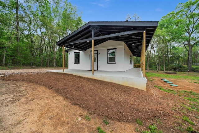 back of property with stucco siding and a patio area