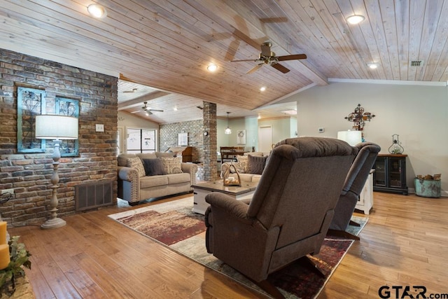 living room with ornate columns, brick wall, vaulted ceiling with beams, and light hardwood / wood-style floors