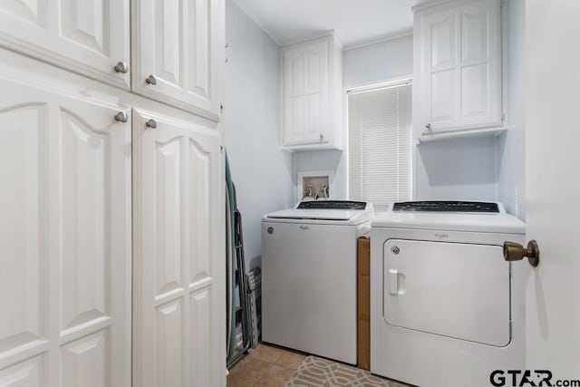 washroom with light tile patterned floors, cabinets, and washing machine and clothes dryer