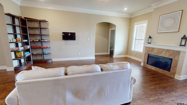 living area featuring arched walkways, wood finished floors, crown molding, and baseboards