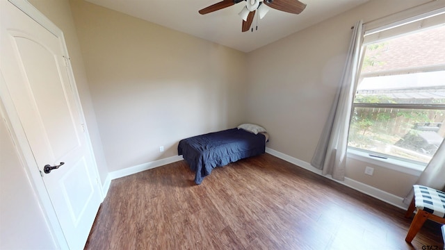 bedroom featuring wood finished floors, a ceiling fan, and baseboards