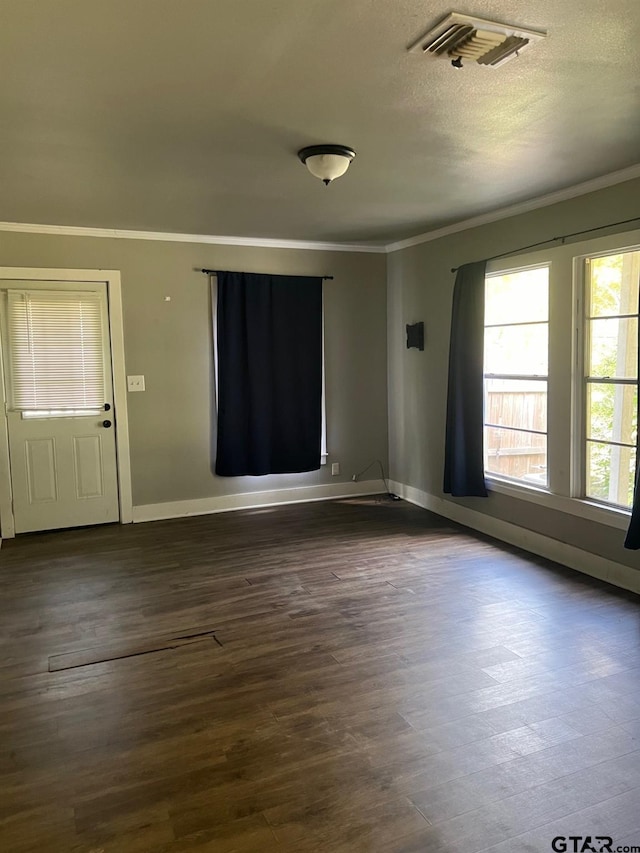 unfurnished room featuring dark wood-type flooring, a textured ceiling, and crown molding