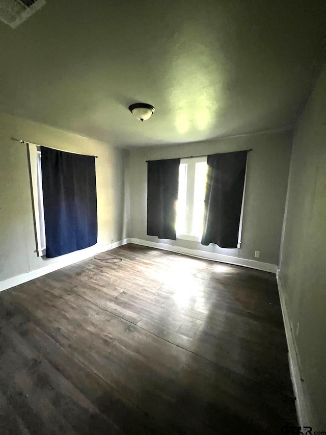 unfurnished room with dark hardwood / wood-style flooring