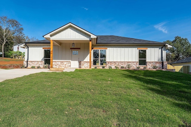 view of front of property with brick siding, board and batten siding, and a front yard