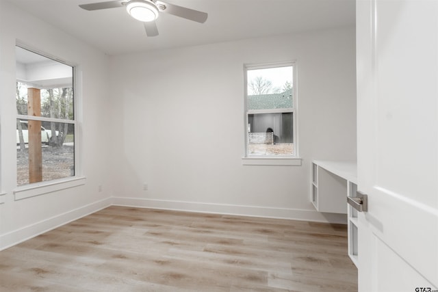 spare room featuring ceiling fan, a healthy amount of sunlight, and light wood-type flooring