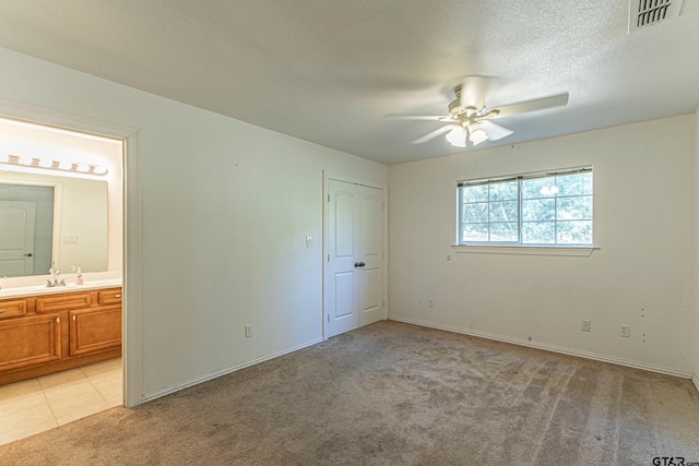 250 Autumn Wood Trl, Holly Lake Ranch, TX 75765 - unfurnished bedroom featuring light colored carpet, connected bathroom, baseboards, ceiling fan, and a textured ceiling