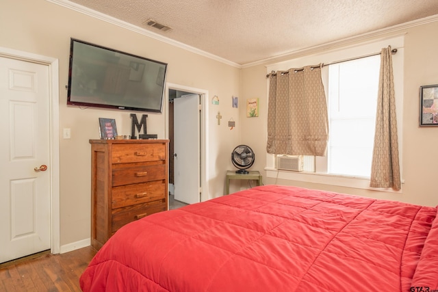 bedroom with dark wood-type flooring, multiple windows, a textured ceiling, and crown molding