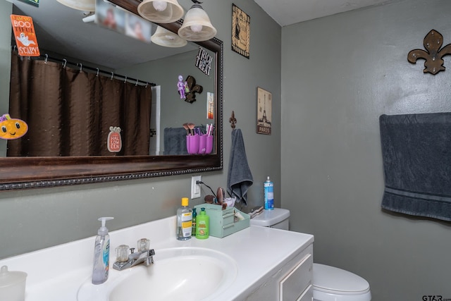 bathroom featuring curtained shower, vanity, and toilet