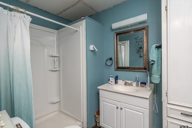 bathroom featuring a shower with curtain, vanity, and a drop ceiling