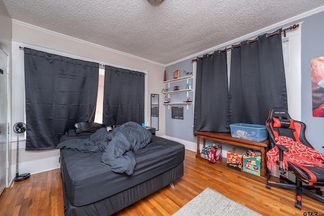 bedroom featuring a textured ceiling, hardwood / wood-style flooring, and ornamental molding