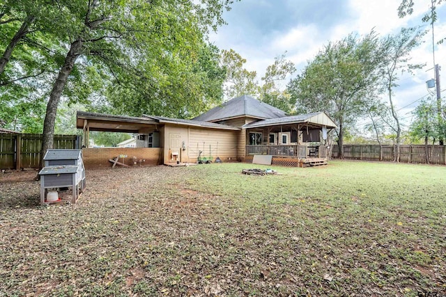 rear view of house featuring a lawn and a wooden deck