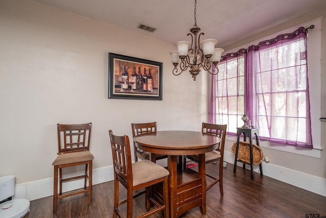 dining room with dark hardwood / wood-style flooring and a chandelier