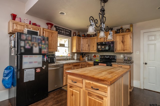 kitchen with black appliances, a kitchen island, hanging light fixtures, sink, and dark wood-type flooring