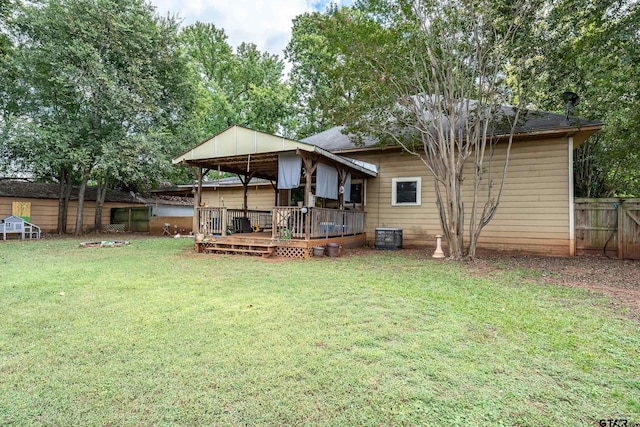 rear view of house featuring a yard and a deck