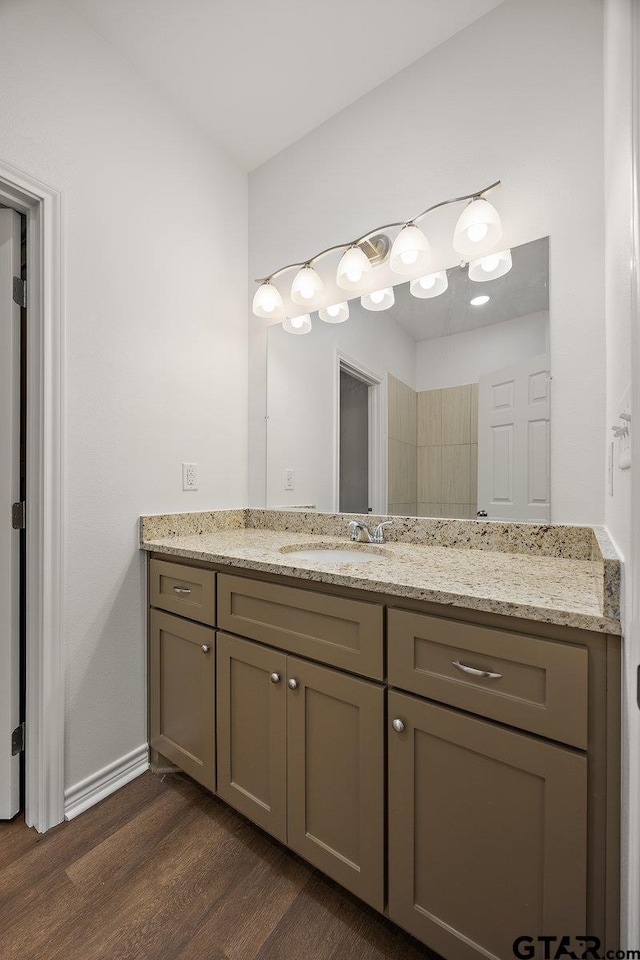 bathroom featuring wood finished floors, vanity, and baseboards