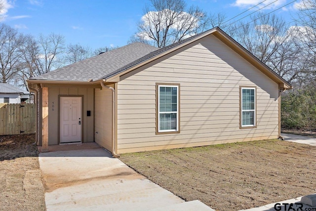 view of front of home featuring a shingled roof and fence