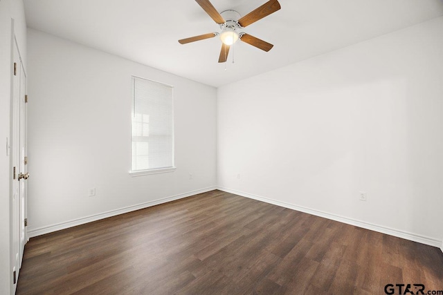 spare room featuring dark wood-style floors, ceiling fan, and baseboards